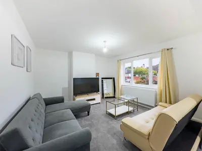 a living room with a couch and a tv at Southend Retreat KING SUITE Luxury stay with parking in Southend-on-Sea