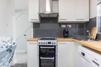 a white kitchen with a stove and a sink at Southend Retreat KING SUITE Luxury stay with parking in Southend-on-Sea