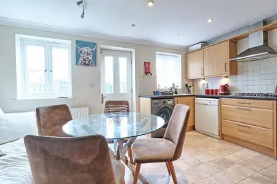 a kitchen with a table and chairs in a room at By Buildersbeds - Paignton House 4 Bedrooms in Harold Wood