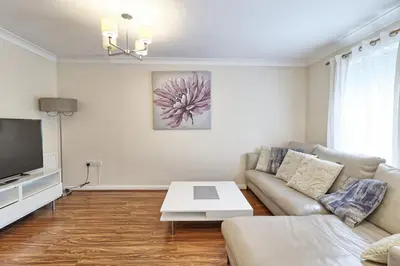 a living room with a couch and a tv at By Buildersbeds - Paignton House 4 Bedrooms in Harold Wood