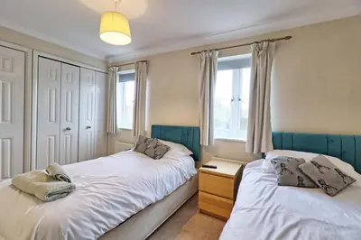 a bedroom with two beds and a window at By Buildersbeds - Paignton House 4 Bedrooms in Harold Wood