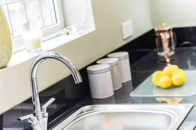 a kitchen counter with a sink and some fruit on a tray at By Buildersbeds - Colne House 4 bedrooms in Harold Wood