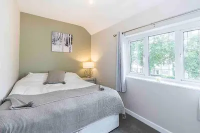 a bedroom with a bed and a window at By Buildersbeds - Colne House 4 bedrooms in Harold Wood