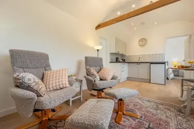 a living room with two chairs and a table at The Old Woodstore in Sudbury