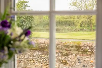 a window with a view of a lake seen through it at The Old Woodstore in Sudbury