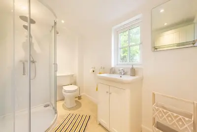 a bathroom with a toilet and a sink and a shower at The Old Woodstore in Sudbury