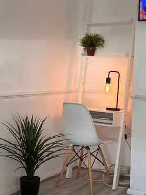 a white desk with a chair next to a plant at By Buildersbeds - Heaton House 2 Bedrooms in Havering atte Bower