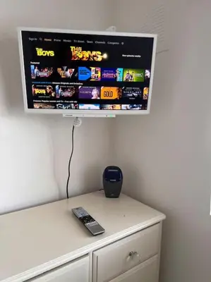 a tv hanging on a wall with a remote control at By Buildersbeds - Heaton House 2 Bedrooms in Havering atte Bower