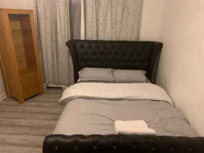 a bed with a black leather headboard in a room at At Apex house in Horndon on the Hill