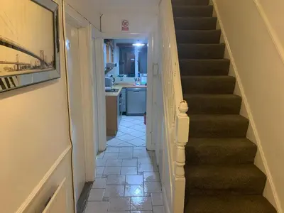 a hallway with a staircase leading to a kitchen at At Apex house in Horndon on the Hill