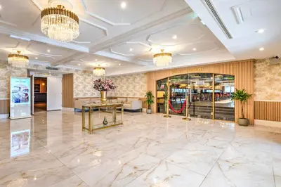 a lobby with a marble floor and chandeliers at Palms Hotel & Retreat By Palette London Romford in Hornchurch