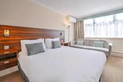 a hotel room with a large bed and a window at Palms Hotel & Retreat By Palette London Romford in Hornchurch
