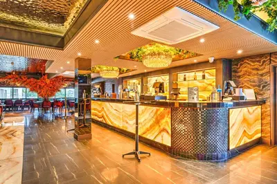 a restaurant with a bar in the middle of a room at Palms Hotel & Retreat By Palette London Romford in Hornchurch