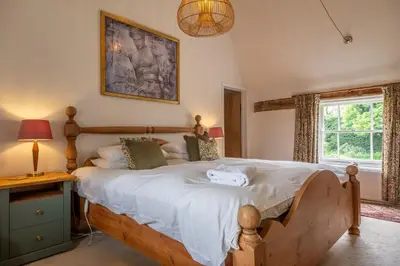 a bedroom with a large bed and a window at Cutbush Farm House 6 in Hingham