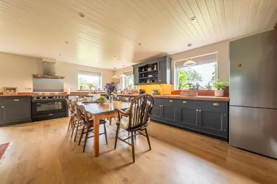 a kitchen with a table and chairs and a refrigerator at Cutbush Farm House 6 in Hingham