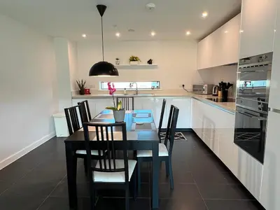 a dining room with a table and chairs in a kitchen at Apartment at Addenbrooke hospital and Bio Campus - Free Private parking in Cambridge