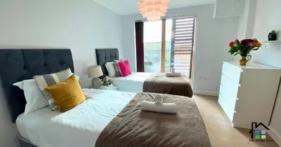 a bedroom with a bed with yellow and pink pillows at Apartment at Addenbrooke hospital and Bio Campus - Free Private parking in Cambridge