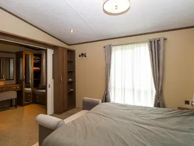 a bedroom with a bed and a window at Lodge 26, Fishing Lakes in Stowmarket