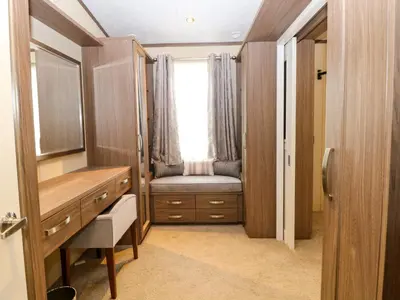 a dressing room with a desk and a window at Lodge 26, Fishing Lakes in Stowmarket