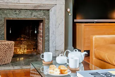 a living room with a fireplace and a coffee table with cups at 5 Bed in Methwold oc-r29770 in Methwold