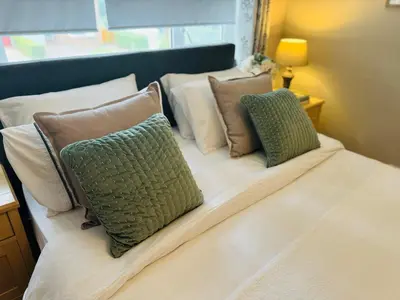 a bed with three pillows on top of it at Bowershott in Letchworth