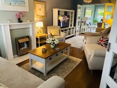 a living room with a fireplace and a table at Bowershott in Letchworth