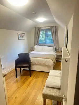 a bedroom with a bed and a chair and a window at The Cosy Place near centre in Ipswich