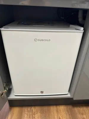 a white refrigerator sitting on top of a floor at The Cosy Place near centre in Ipswich