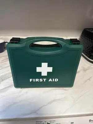 a green first aid bag sitting on top of a bed at The Cosy Place near centre in Ipswich
