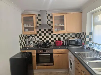 a kitchen with a black and white checkered wall at Accessible Flat Greater London in Upminster
