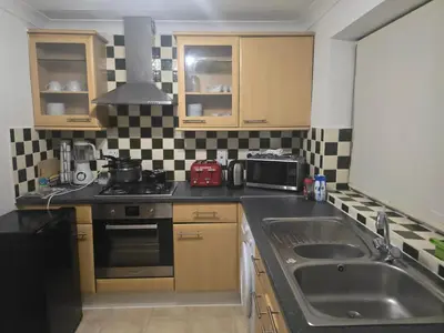a small kitchen with a sink and a stove at Accessible Flat Greater London in Upminster