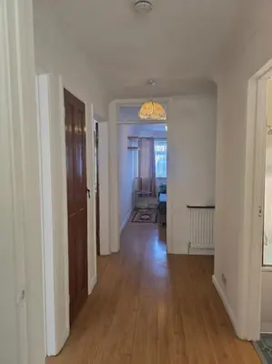 an empty room with a hallway with a wooden floor at Accessible Flat Greater London in Upminster