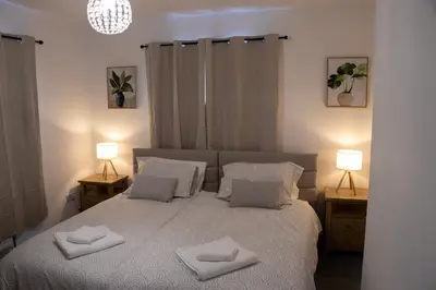 a bedroom with a bed with two lamps on tables at Comfortable 3 bed house in central location, Stevenage in Stevenage