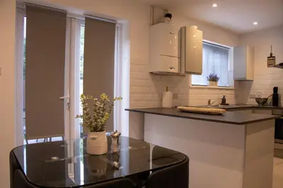 a kitchen with a glass table and a counter at Comfortable 3 bed house in central location, Stevenage in Stevenage