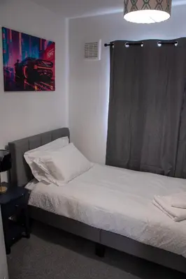 a small bedroom with two beds and a window at Comfortable 3 bed house in central location, Stevenage in Stevenage