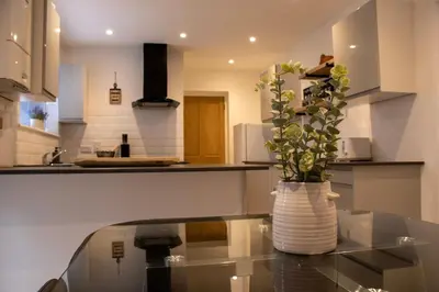 a vase with a plant sitting on a glass table in a kitchen at Comfortable 3 bed house in central location, Stevenage in Stevenage