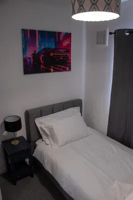 a bedroom with a bed and a painting on the wall at Comfortable 3 bed house in central location, Stevenage in Stevenage