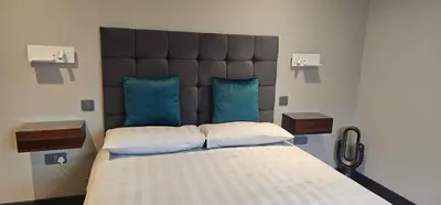 a bedroom with a large bed with a large headboard at Luxury Non Smoking 2 bedroom retreat in Norfolk in Attleborough