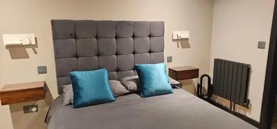 a large bed with blue pillows in a room at Luxury Non Smoking 2 bedroom retreat in Norfolk in Attleborough