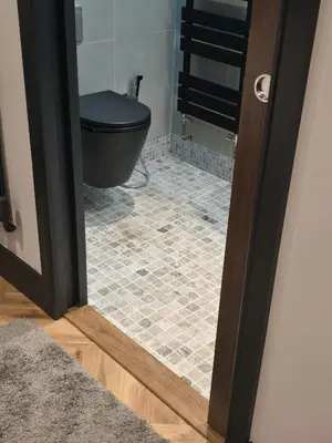 a bathroom with a black toilet and a tile floor at Luxury Non Smoking 2 bedroom retreat in Norfolk in Attleborough