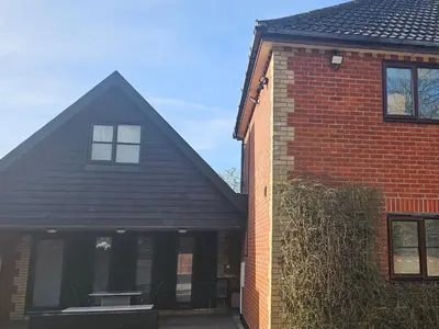 a red brick house with a black roof at Luxury Non Smoking 2 bedroom retreat in Norfolk in Attleborough