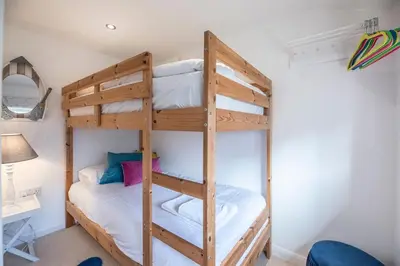 a bunk bed in a room with a ladder at Beachcomber, Aldeburgh in Aldeburgh