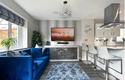 a living room with a blue couch and a kitchen at Colchester Spacious Double Rooms in CO4 in Mile End