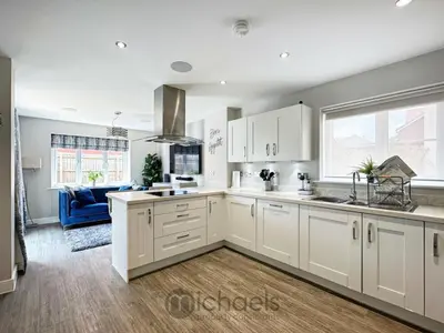 a kitchen with white cabinets and a blue couch at Colchester Spacious Double Rooms in CO4 in Mile End