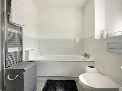 a white bathroom with a tub and a toilet at Colchester Spacious Double Rooms in CO4 in Mile End