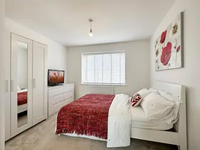 a white bedroom with a bed and a television at Colchester Spacious Double Rooms in CO4 in Mile End