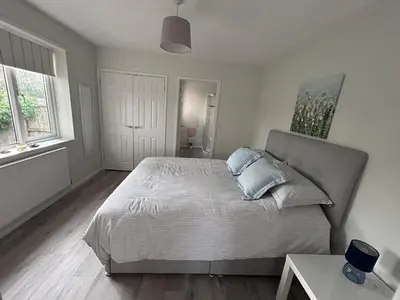 a bedroom with a bed with blue pillows on it at Hamble House Holiday Let in Woodbridge