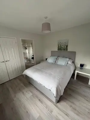 a bedroom with a large white bed with a white door at Hamble House Holiday Let in Woodbridge