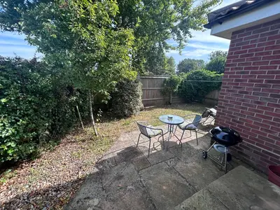 a patio with a table and chairs and a grill at Hamble House Holiday Let in Woodbridge