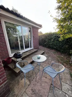a patio with two chairs and a table and a grill at Hamble House Holiday Let in Woodbridge